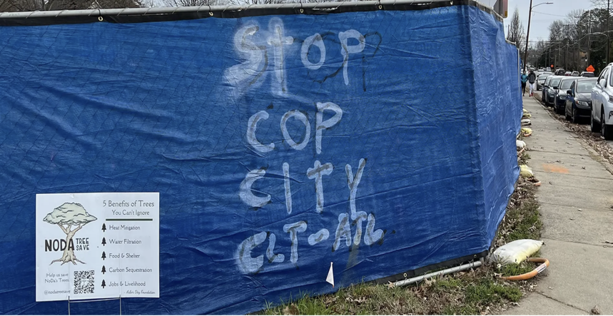 A spray-painted message left on a construction fence on North Alexander Street in NoDa. The message reads, “Stop Cop City CLT-ATL,” and references the national pushback in Atlanta against police training facilities. 