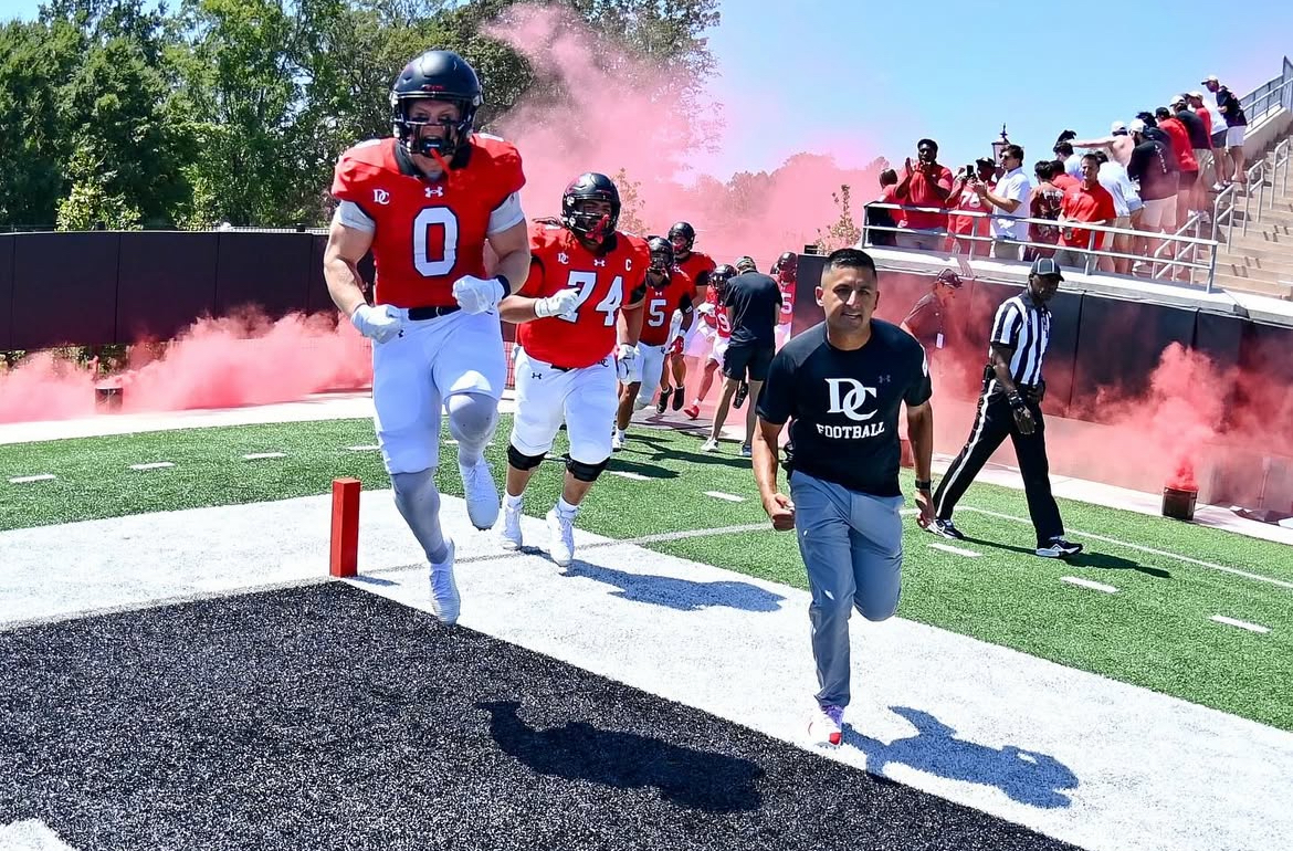 Running Back Mason Sheron ’26 and Head Coach Saj Thakkar lead the ’Cats onto the field. 