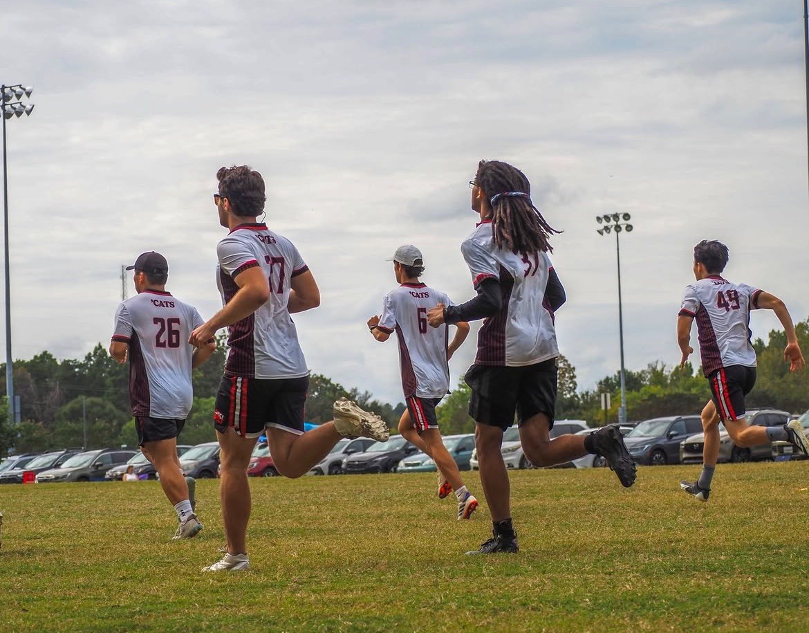 Athletes jog across the field during warmups. 