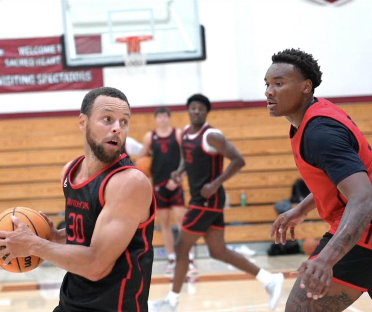 Stephen Curry matches up against Josh Scovens '27 during a Bay Area mini camp in July 