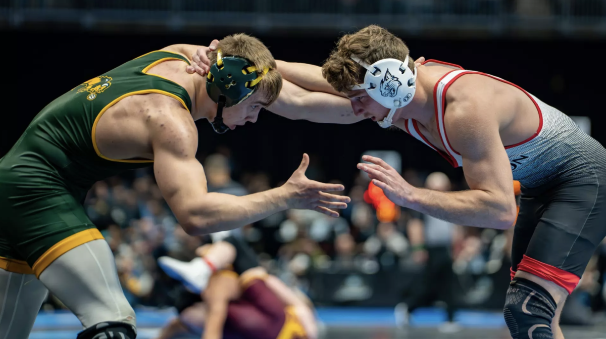 Anderson Heap ’28 on the mat wrestling North Dakota State University’s Max Peterson.